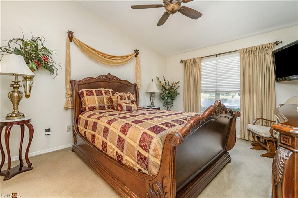 367 Dover Place, Unit 1006 Naples, FL 34104 - Photo 16 of 31 a bedroom with a bed mirror and a flat tv screen on the dresser