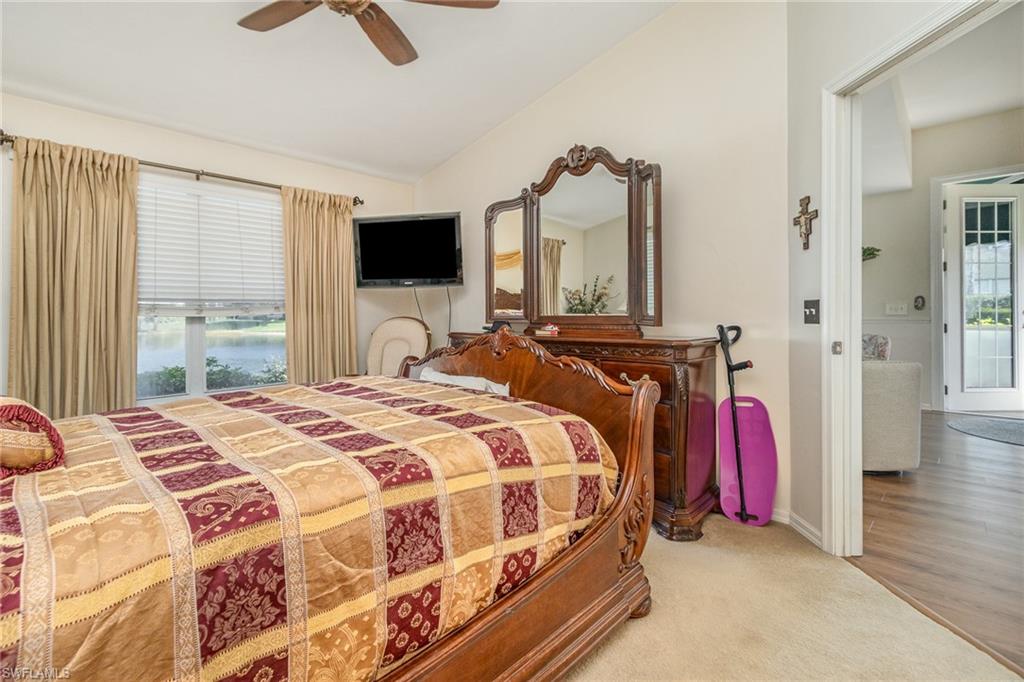 367 Dover Place, Unit 1006 Naples, FL 34104 - Photo 18 of 31 a bedroom with a bed a flat screen tv and a large window