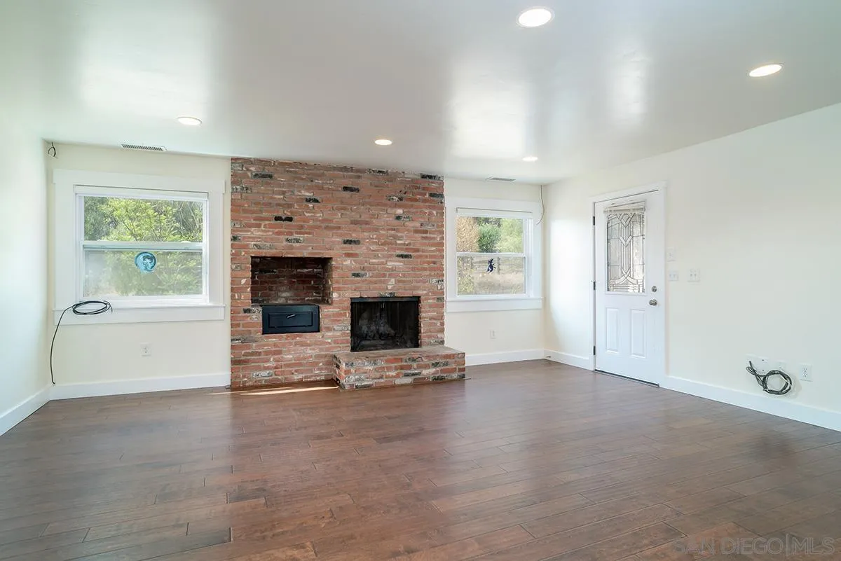 6777 West Lilac Road Bonsall, CA 92003 - Photo 14 of 36 an empty room with windows and fireplace