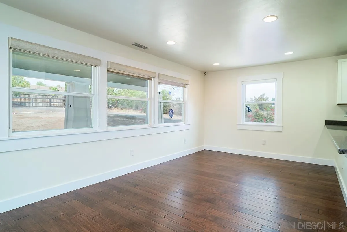 6777 West Lilac Road Bonsall, CA 92003 - Photo 17 of 36 a view of an empty room with wooden floor and a window