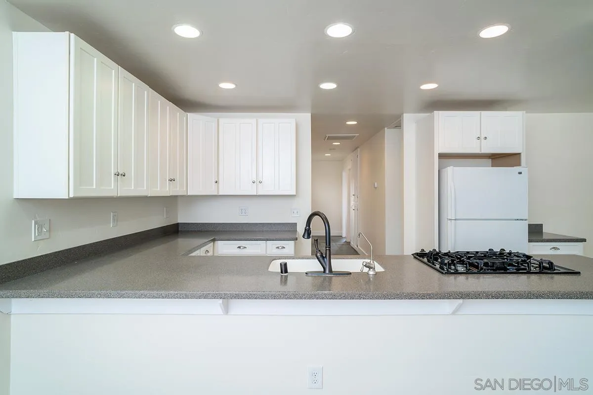 6777 West Lilac Road Bonsall, CA 92003 - Photo 19 of 36 a kitchen with a sink and white cabinets
