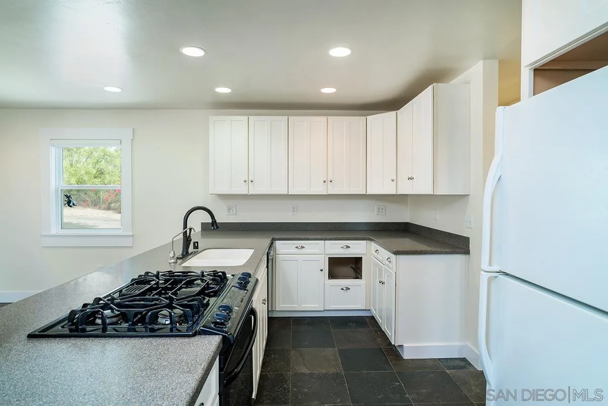 6777 West Lilac Road Bonsall, CA 92003 - Photo 20 of 36 a kitchen with a stove and a refrigerator