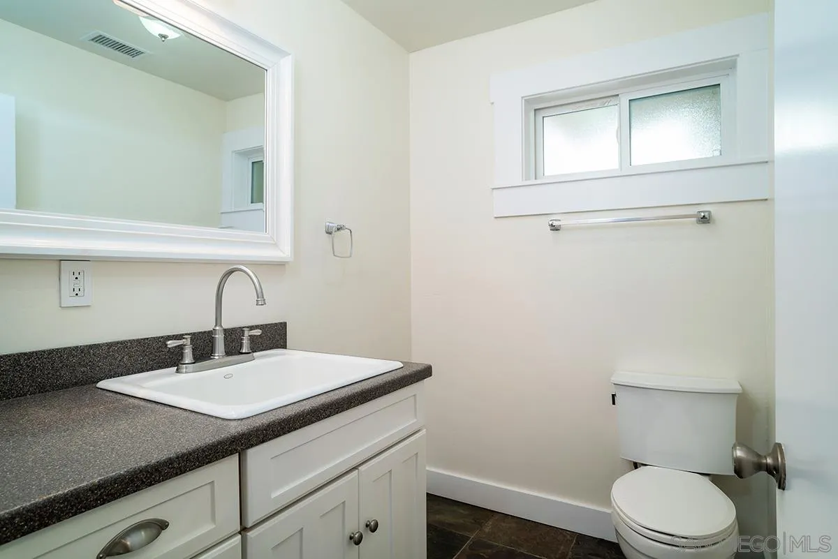 6777 West Lilac Road Bonsall, CA 92003 - Photo 22 of 36 a bathroom with a sink a toilet and mirror