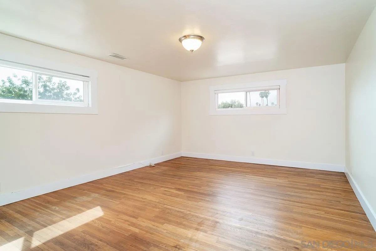 6777 West Lilac Road Bonsall, CA 92003 - Photo 26 of 36 an empty room with wooden floor and windows