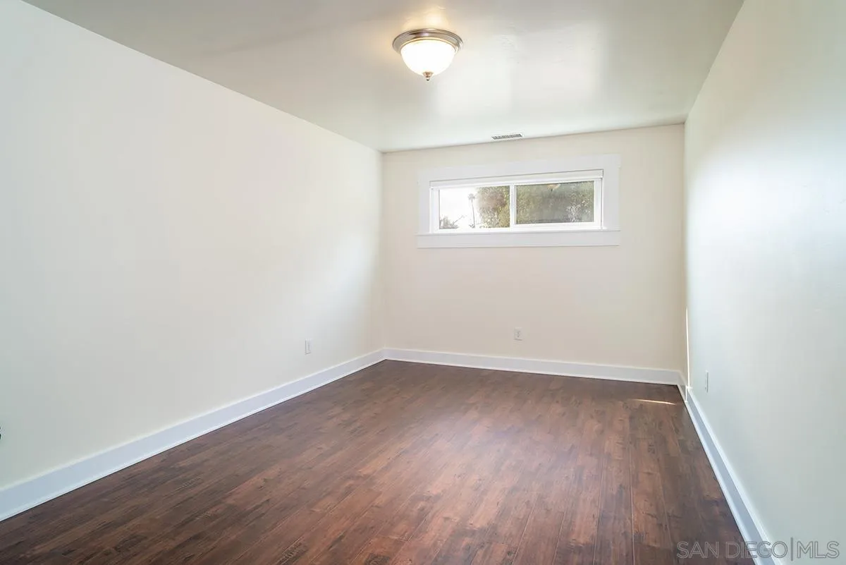 6777 West Lilac Road Bonsall, CA 92003 - Photo 28 of 36 an empty room with wooden floor and windows