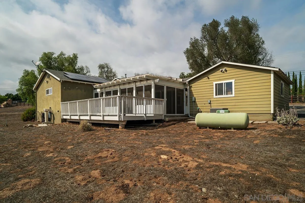 6777 West Lilac Road Bonsall, CA 92003 - Photo 35 of 36 a view of a house with a yard and wooden fence