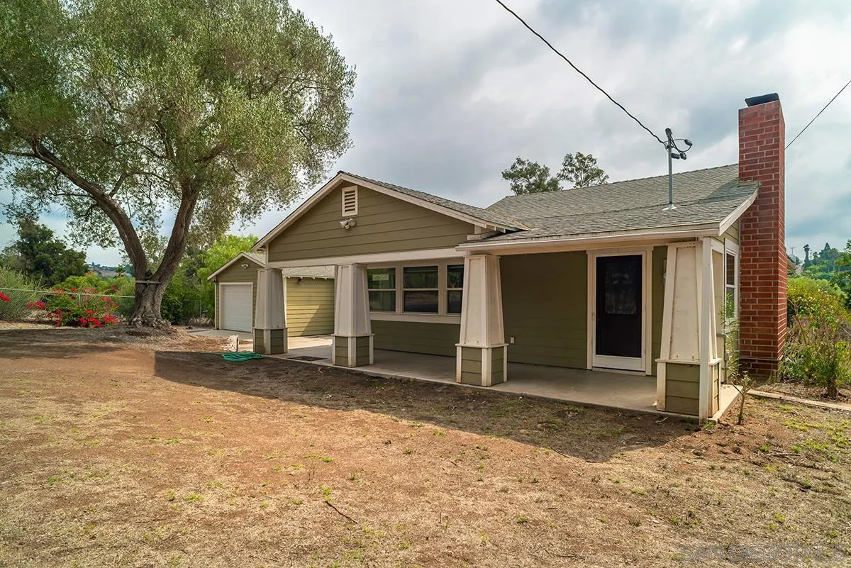 6777 West Lilac Road Bonsall, CA 92003 - Photo 10 of 36 a front view of a house with a yard and garage