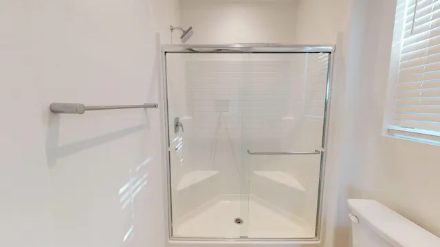 a view of a white house with potted plants and a dining table