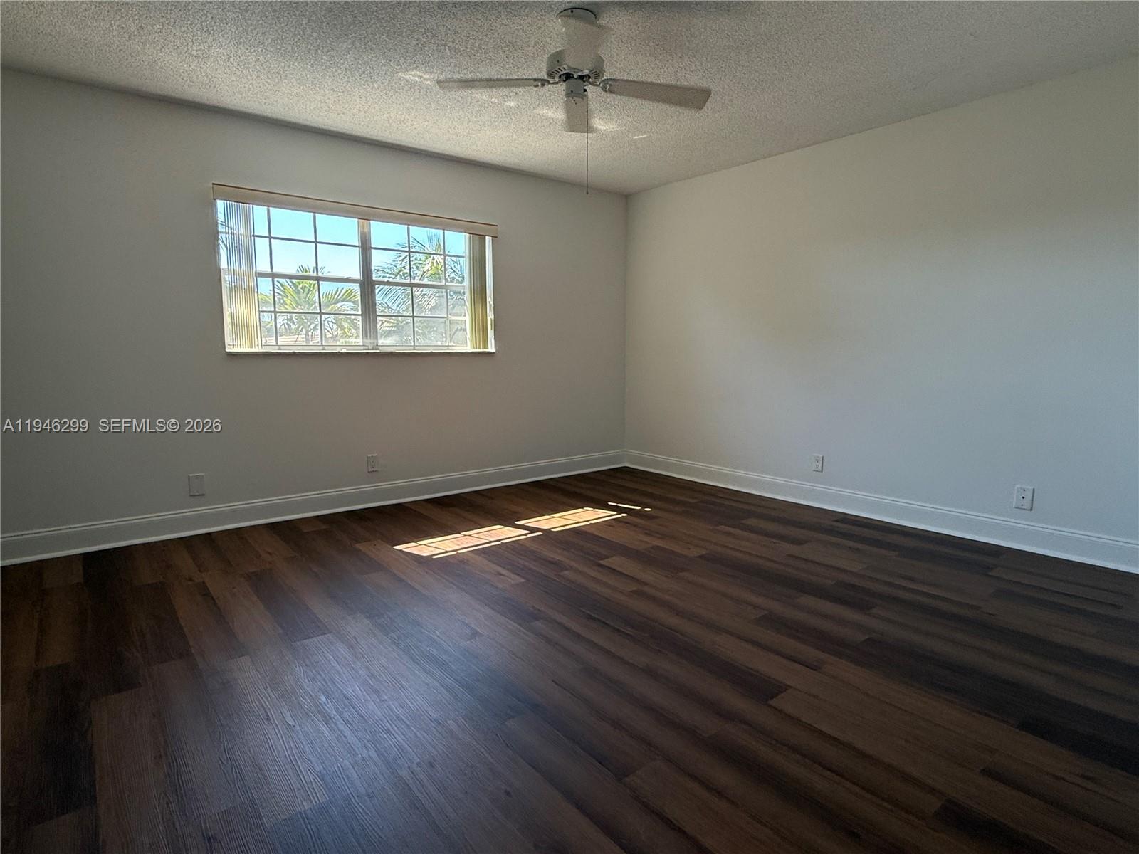 8900 West Sample Road, Unit 204 Coral Springs, FL 33065 - Photo 13 of 21 a view of an empty room with wooden floor and a window
