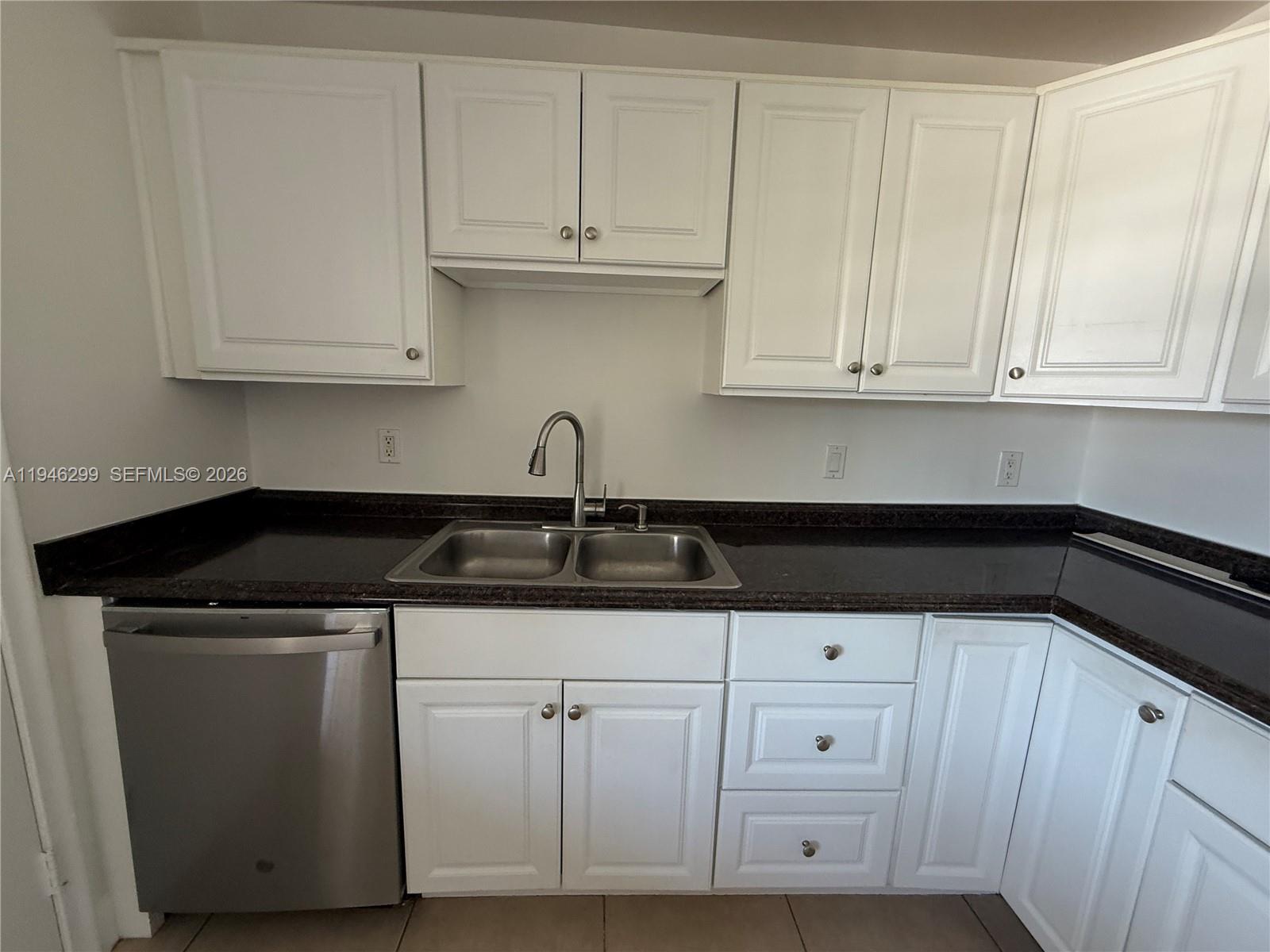 8900 West Sample Road, Unit 204 Coral Springs, FL 33065 - Photo 4 of 21 a kitchen with white cabinets and a sink