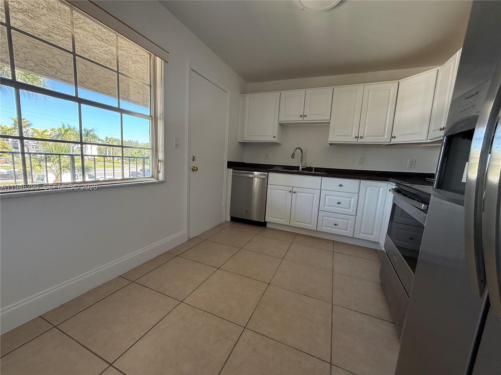 8900 West Sample Road, Unit 204 Coral Springs, FL 33065 - Photo 5 of 21 a kitchen with a sink a refrigerator and window