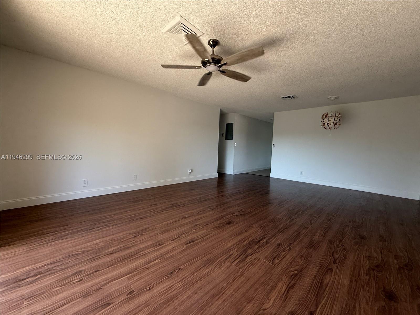 8900 West Sample Road, Unit 204 Coral Springs, FL 33065 - Photo 7 of 21 an empty room with wooden floor a ceiling fan and wooden floor