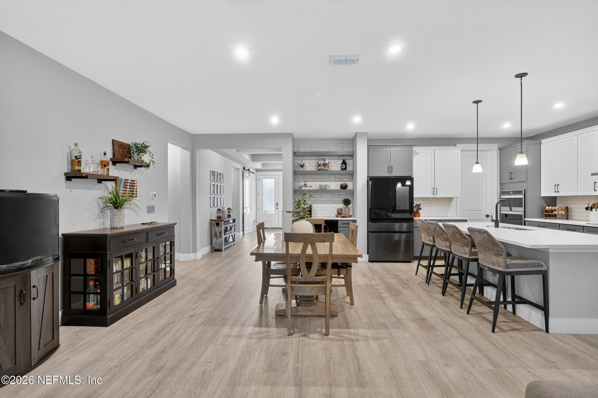 4028 Little Bit Court Middleburg, FL 32068 - Photo 15 of 47 a open kitchen with stainless steel appliances kitchen island granite countertop a dining table chairs and a refrigerator