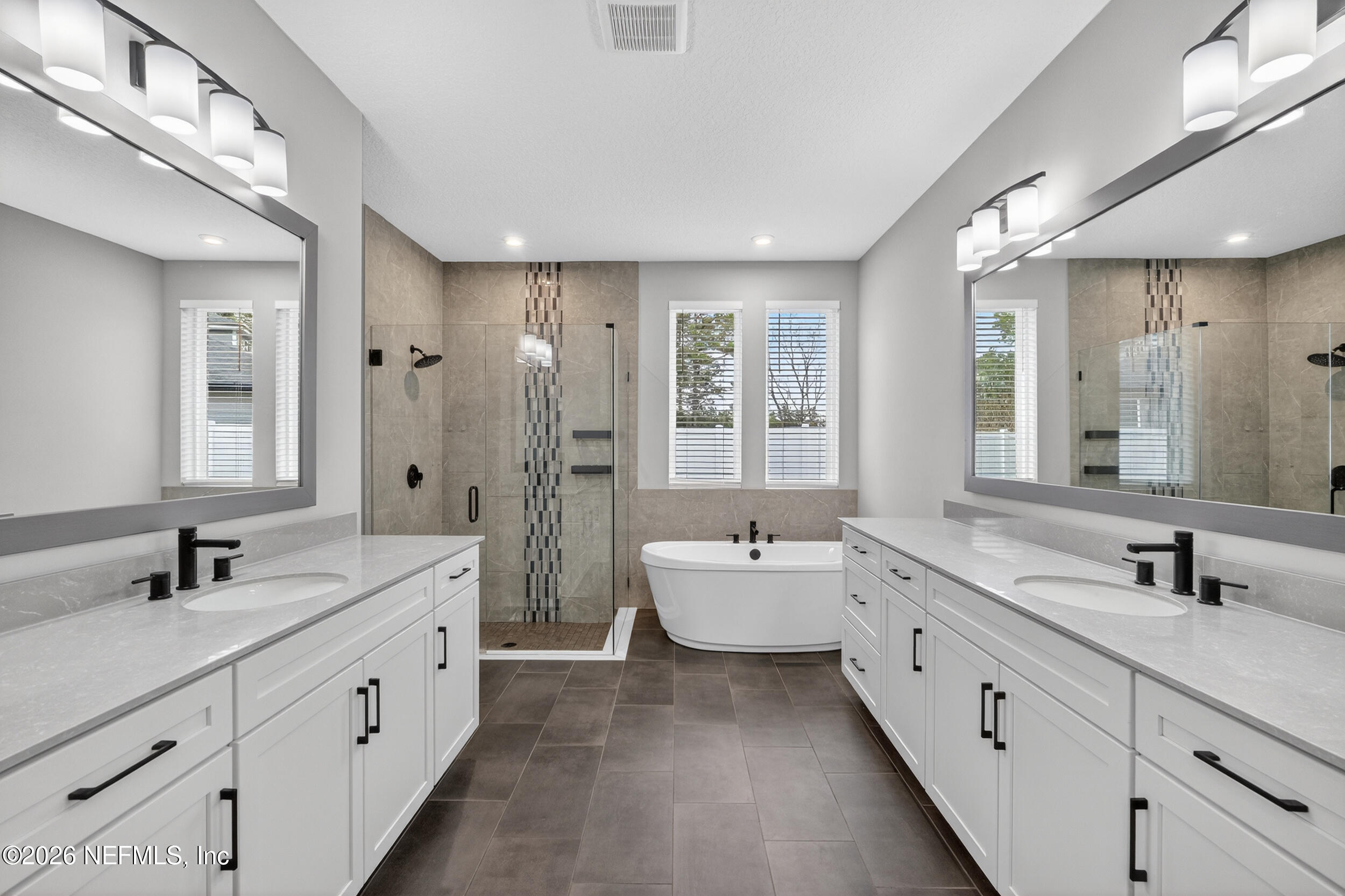 4028 Little Bit Court Middleburg, FL 32068 - Photo 25 of 47 a spacious bathroom with double vanity a sink a mirror a shower and a bathtub