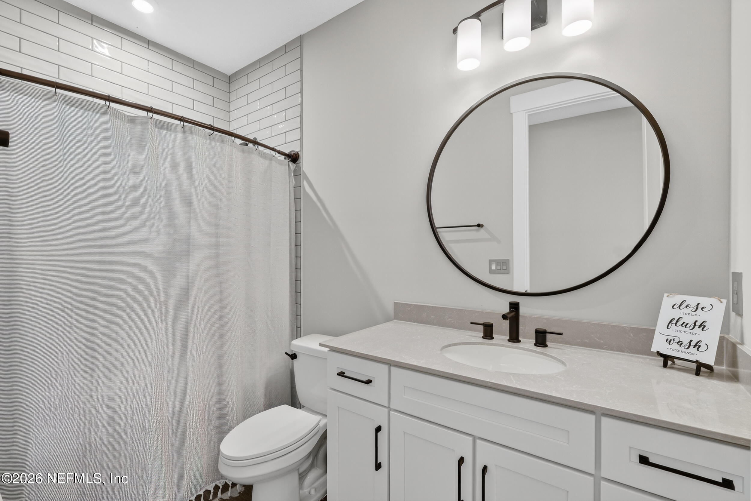 4028 Little Bit Court Middleburg, FL 32068 - Photo 33 of 47 a bathroom with a sink a mirror a toilet and a window