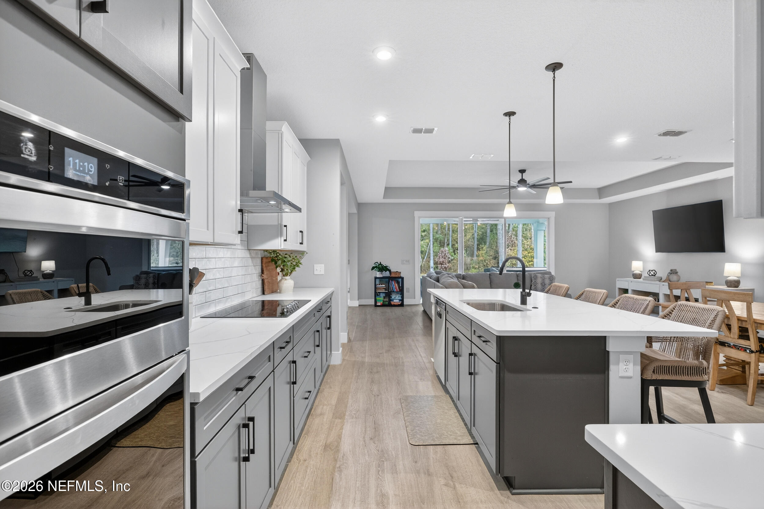 4028 Little Bit Court Middleburg, FL 32068 - Photo 9 of 47 a large kitchen with kitchen island a sink stove and white cabinets