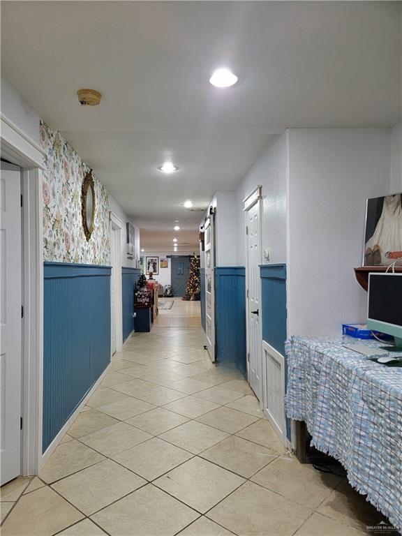 206 South Arroyo Boulevard Rio Hondo, TX 78583 - Photo 15 of 42 Hall from the bedroom with wainscoting, recessed lighting, light tile patterned floors, wallpapered walls, and a barn door