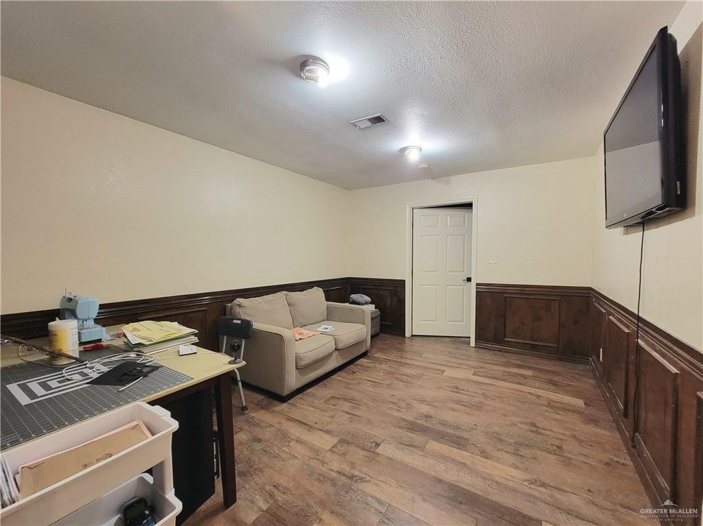 206 South Arroyo Boulevard Rio Hondo, TX 78583 - Photo 20 of 42 Home office featuring a wainscoted wall, wood finished floors, and a textured ceiling