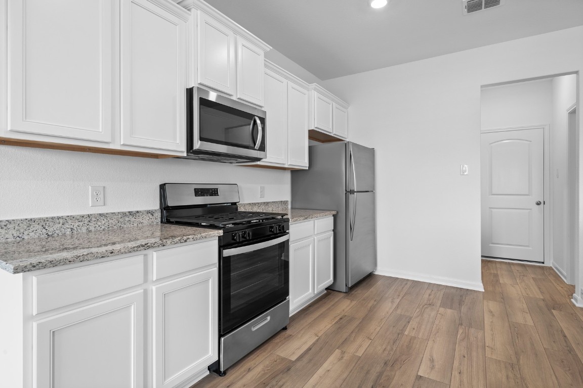 346 Low Pasture Trail Maxwell, TX 78656 - Photo 2 of 10 a kitchen with stainless steel appliances granite countertop a stove a refrigerator and a microwave