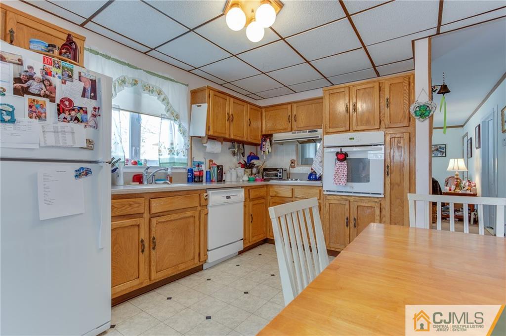 16 Fulton Road Somerset, NJ 08873 - Photo 3 of 25 a kitchen with stainless steel appliances granite countertop a refrigerator a sink dishwasher and white cabinets next to a window