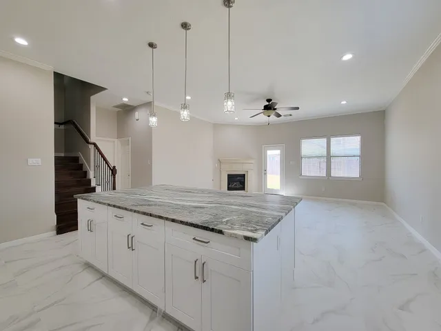 a kitchen with granite countertop a sink and chandelier