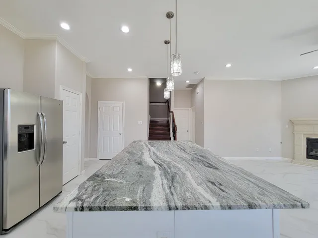 a large kitchen with kitchen island a sink stainless steel appliances and a counter top