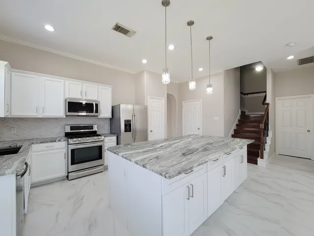 a kitchen with granite countertop a sink and stainless steel appliances