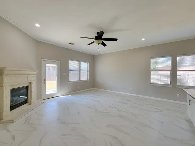 a view of an empty room with a fireplace and a window