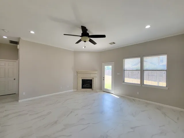 an empty room with windows and fireplace
