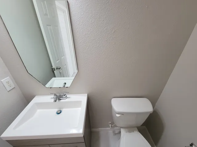 a bathroom with a sink a toilet and mirror