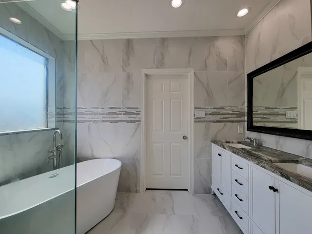 a bathroom with a tub a sink and mirrors