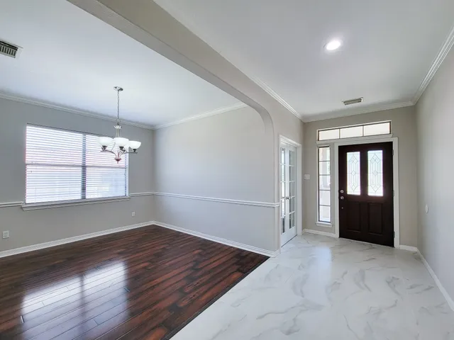 an empty room with windows and cabinet