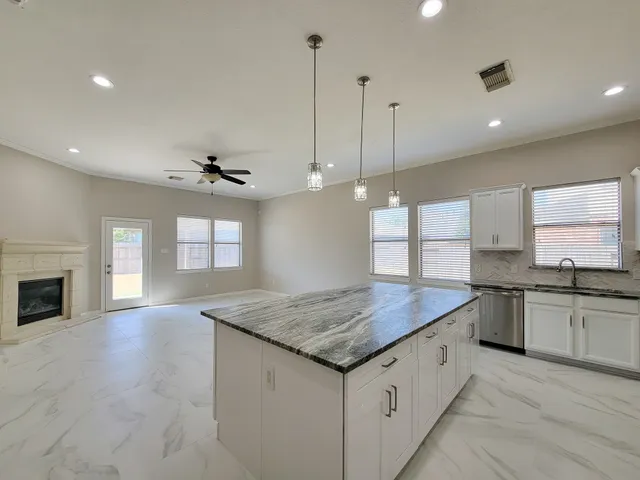 a kitchen with granite countertop cabinets a sink a window and stainless steel appliances