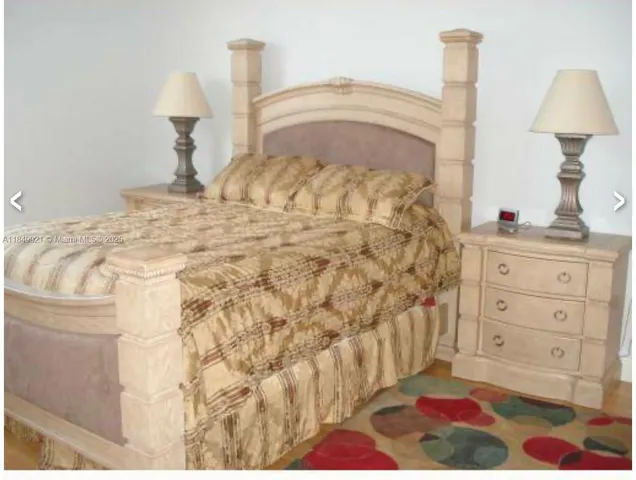 a bedroom with a bed and a lamp on dresser