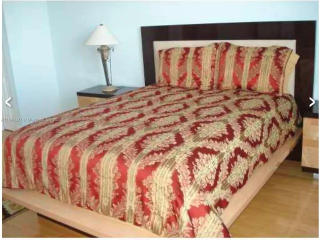 a large bed sitting in a bedroom next to a window