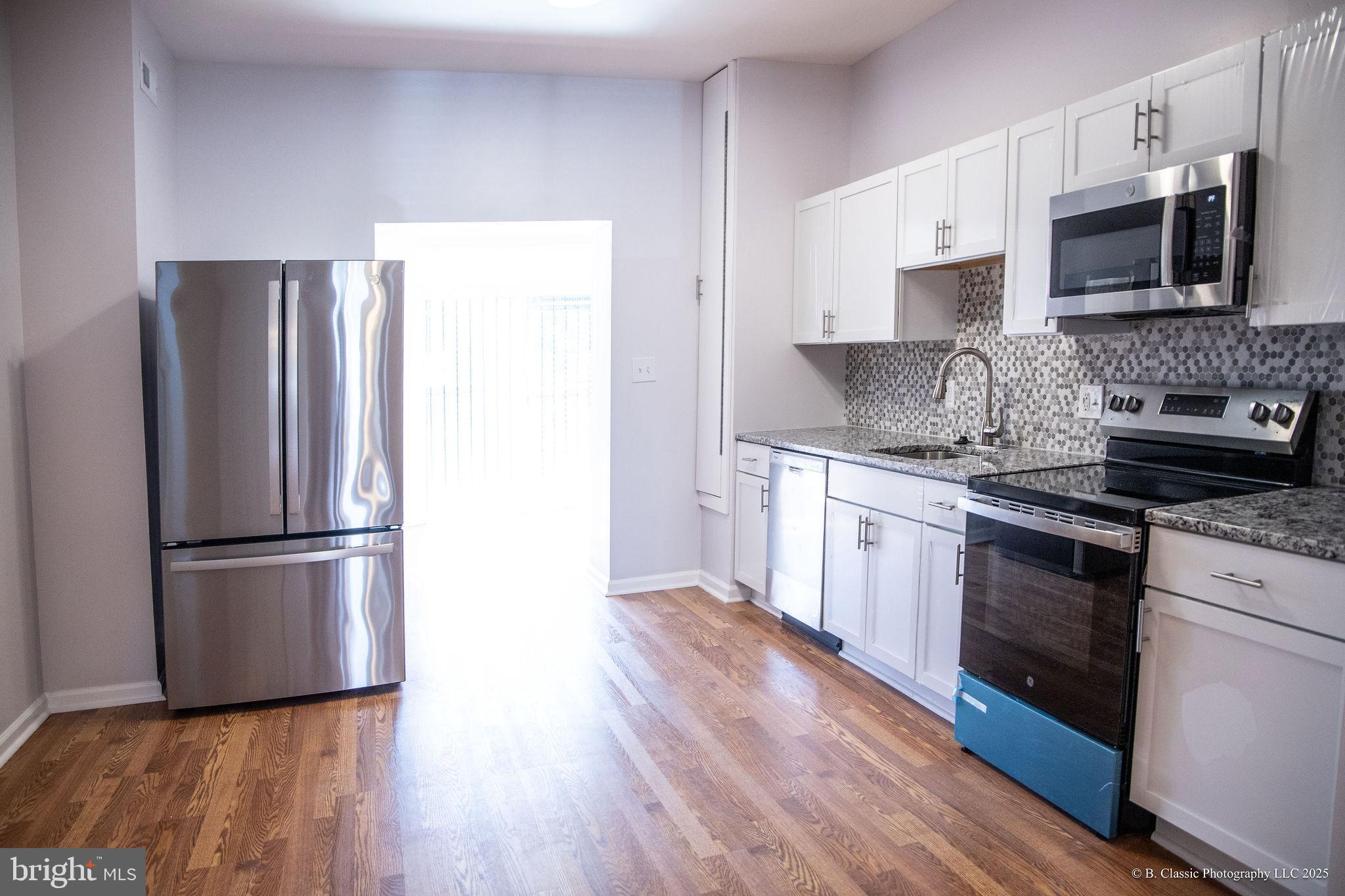 3035 West Belvedere Avenue Baltimore, MD 21215 - Photo 14 of 49 a kitchen with stainless steel appliances a refrigerator sink and microwave