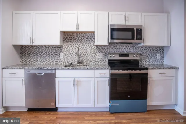 a kitchen with stainless steel appliances granite countertop a stove microwave and oven