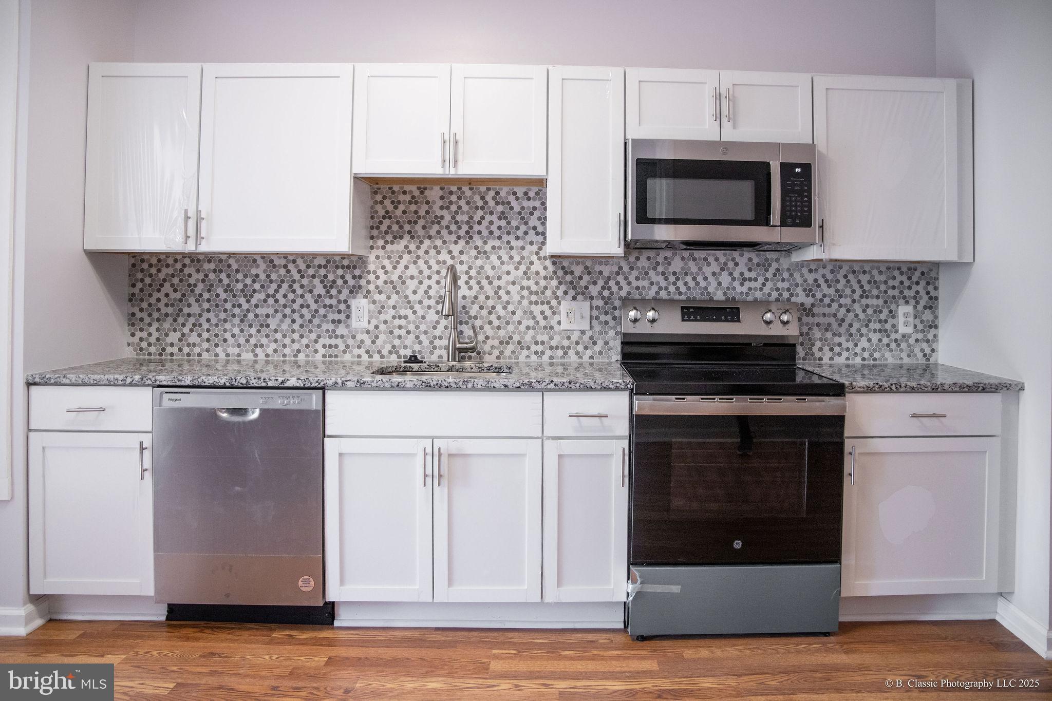 3035 West Belvedere Avenue Baltimore, MD 21215 - Photo 15 of 49 a kitchen with stainless steel appliances granite countertop a stove microwave and oven