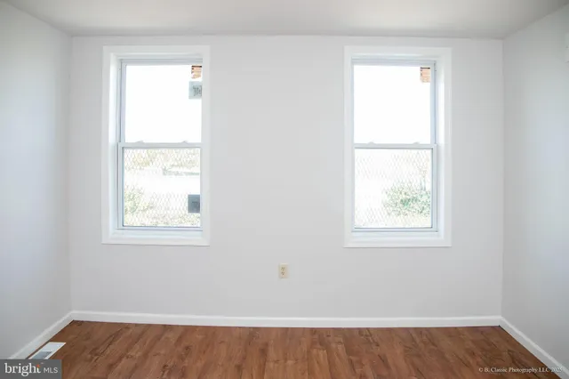 an empty room with wooden floor and a window