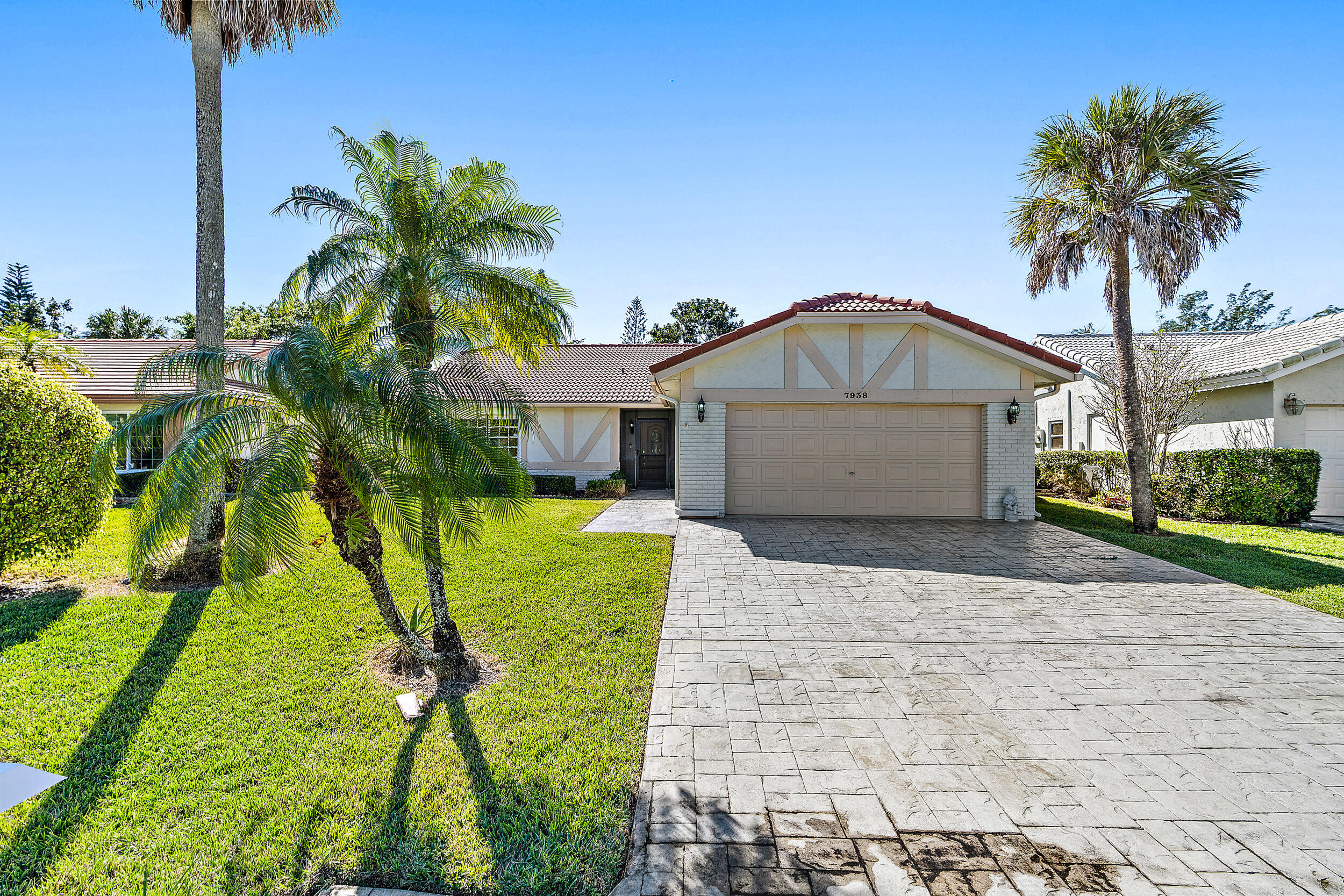 7938 Cloverfield Circle Boca Raton, FL 33433 - Photo 1 of 27 a front view of a house with a yard and garage