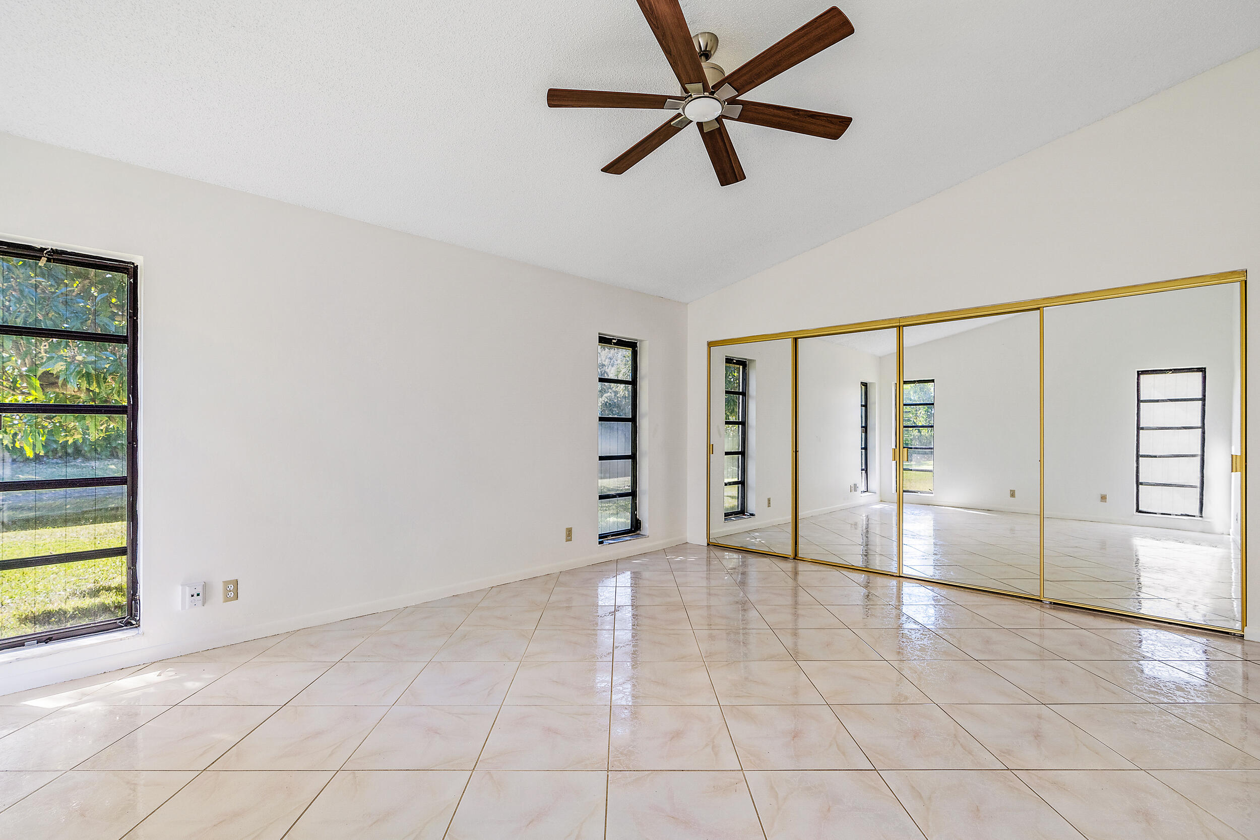 7938 Cloverfield Circle Boca Raton, FL 33433 - Photo 13 of 27 an empty room with windows and ceiling fan