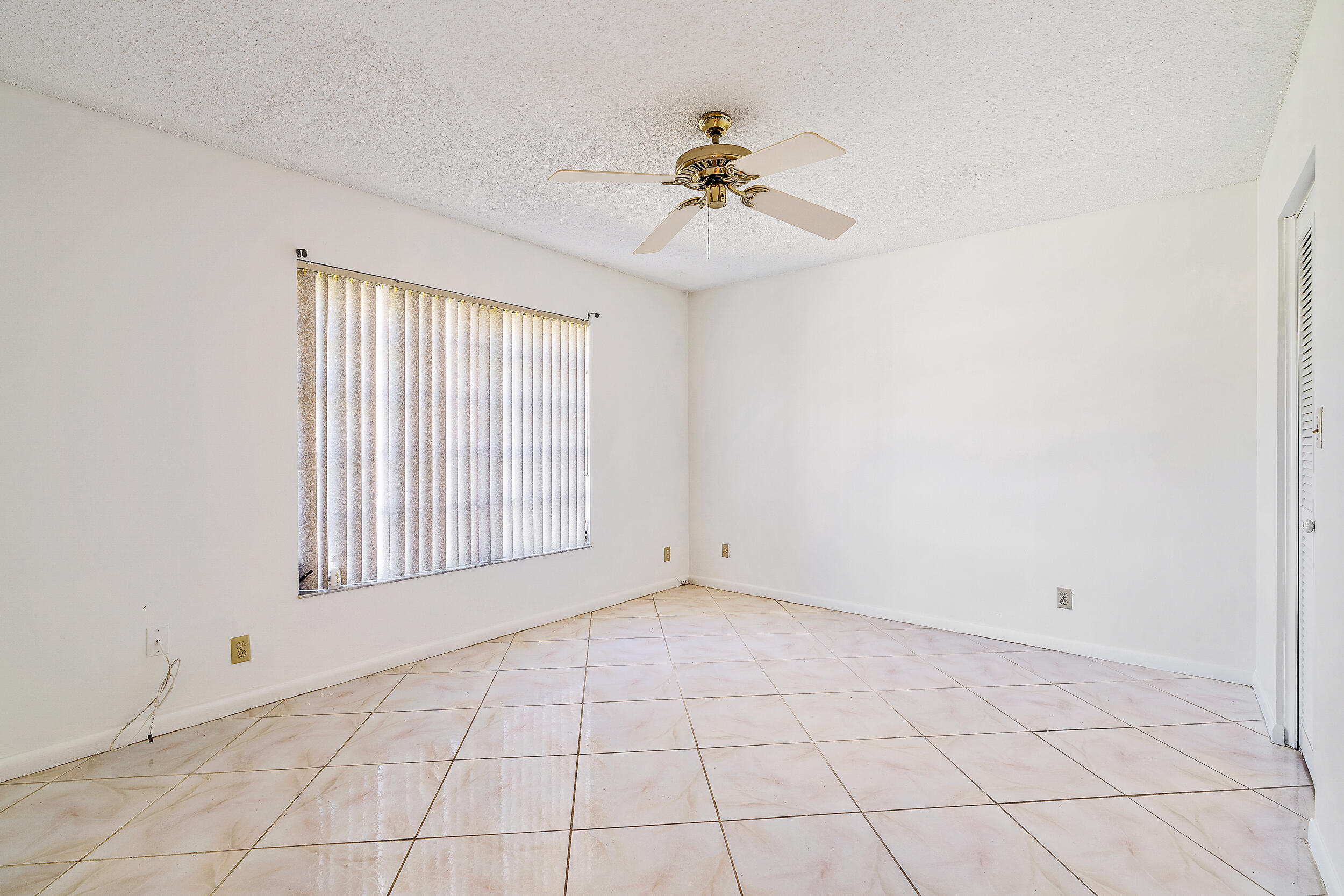 7938 Cloverfield Circle Boca Raton, FL 33433 - Photo 17 of 27 an empty room with windows and chandelier fan