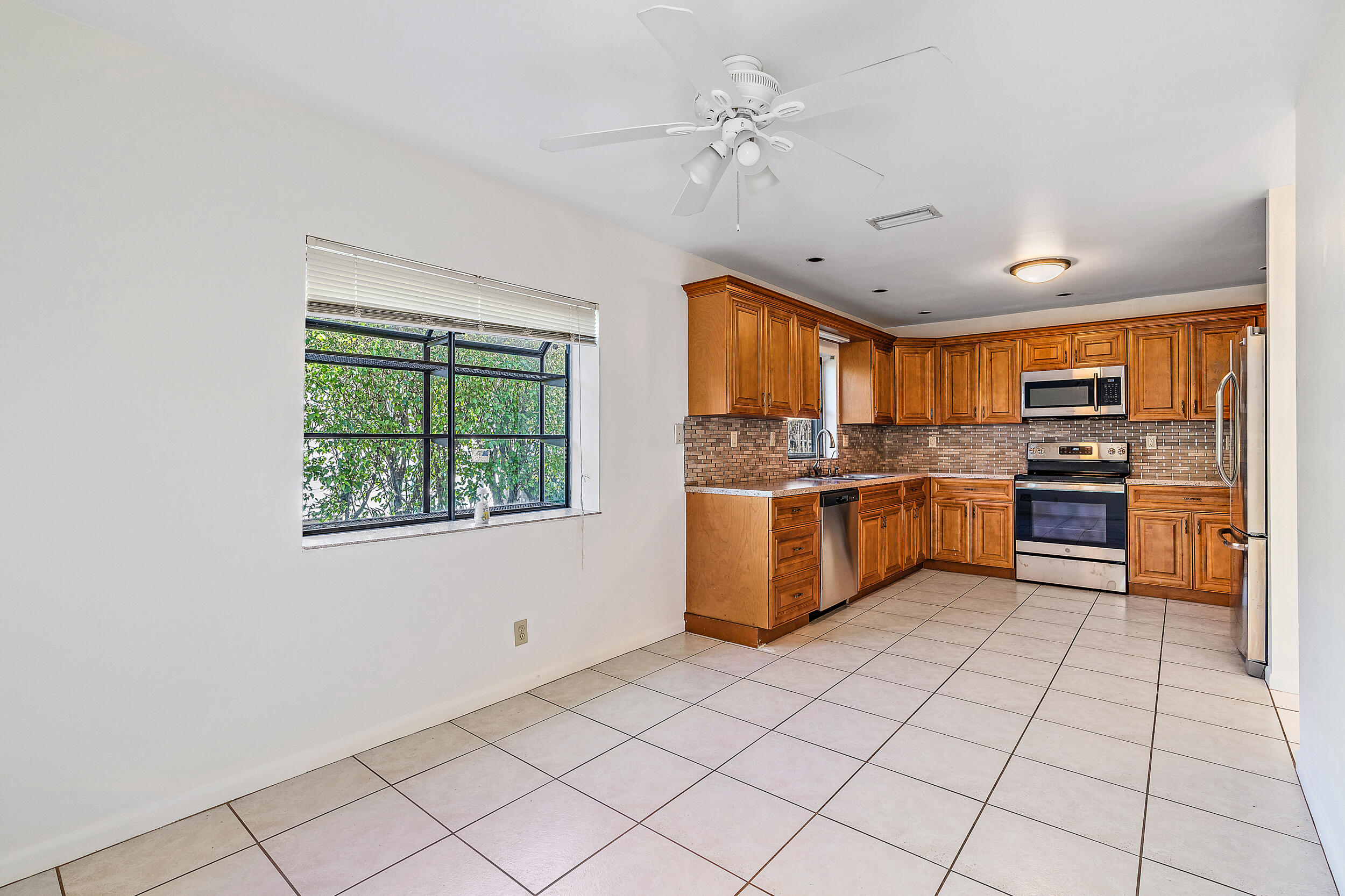 7938 Cloverfield Circle Boca Raton, FL 33433 - Photo 8 of 27 a large kitchen with stainless steel appliances granite countertop a stove a sink dishwasher and a refrigerator