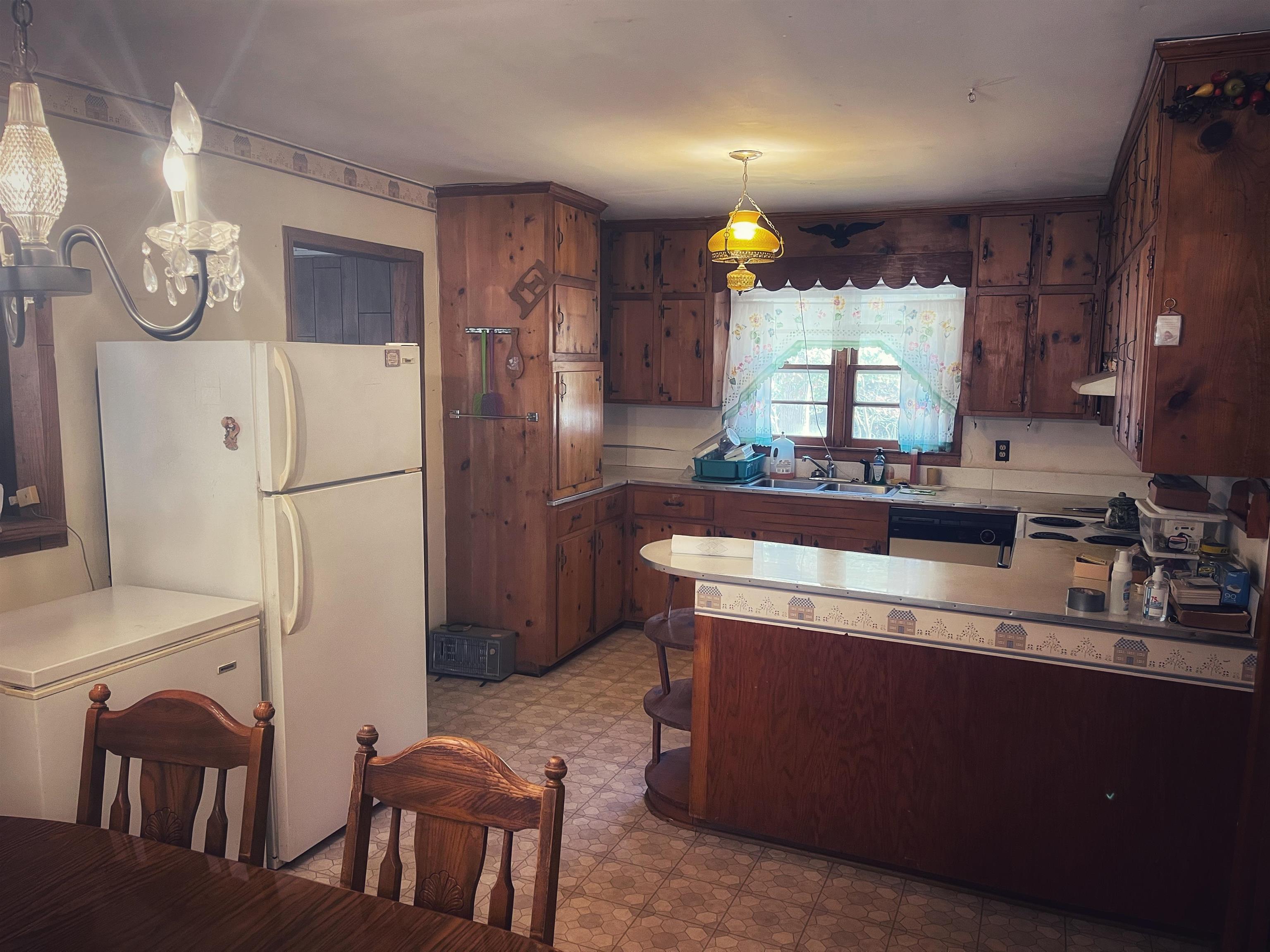 2168 Shawnettee Road Collinwood, TN 38450 - Photo 25 of 25 a kitchen with stainless steel appliances granite countertop a refrigerator a sink dishwasher a stove a dining table and chairs with wooden floor