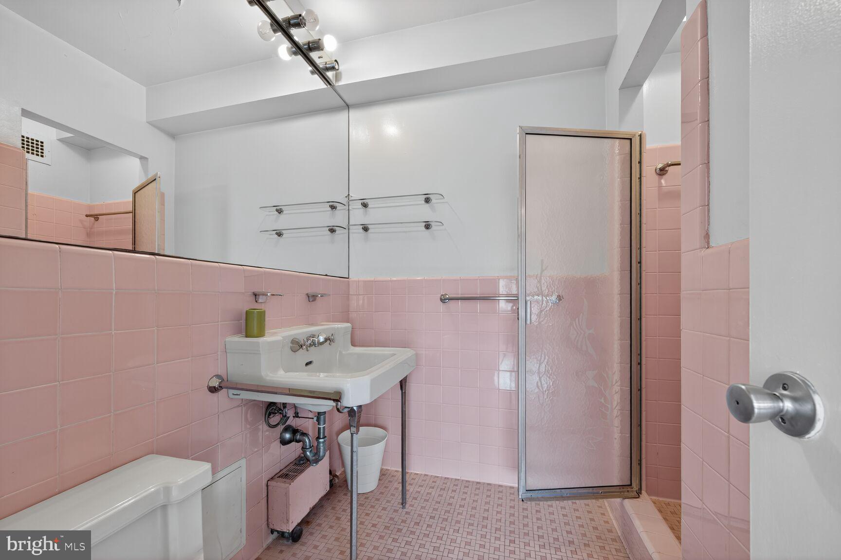 4301 Massachusetts Avenue Northwest, Unit 5009 Washington, DC 20016 - Photo 9 of 14 a bathroom with a sink a mirror and a shower