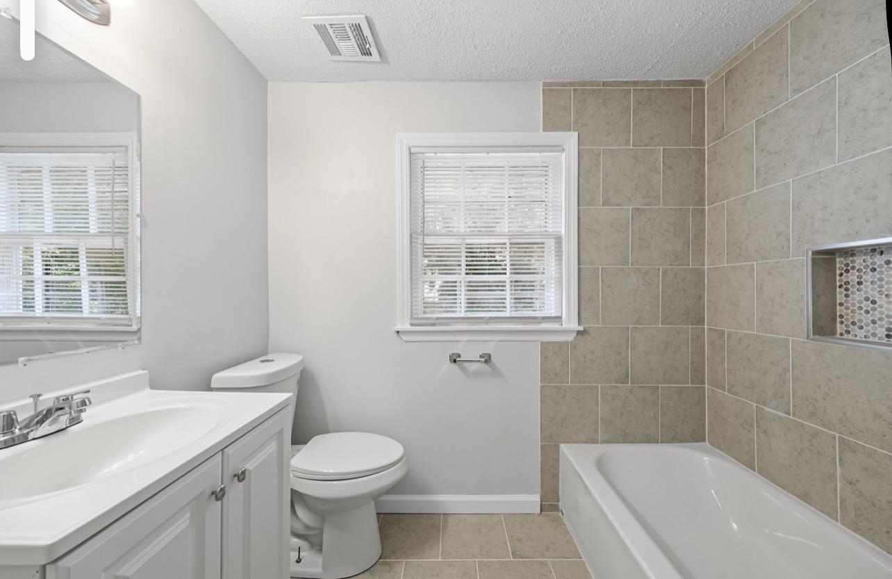 3843 Blue Jay Road Memphis, TN 38116 - Photo 18 of 23 Full bathroom featuring vanity, a garden tub, a textured ceiling, and light tile patterned flooring