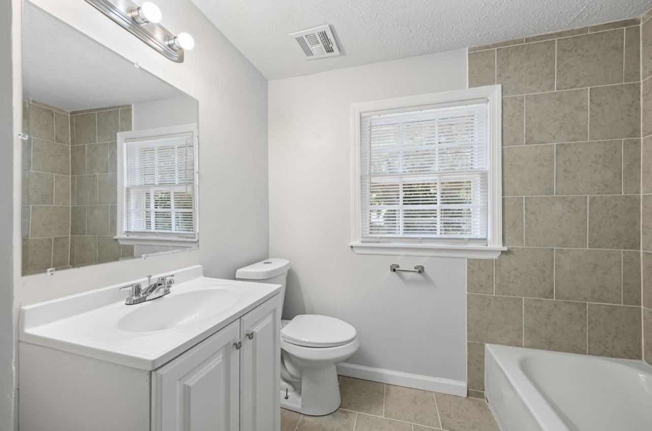 3843 Blue Jay Road Memphis, TN 38116 - Photo 19 of 23 Bathroom featuring vanity, a tub to relax in, a textured ceiling, plenty of natural light, and light tile patterned flooring