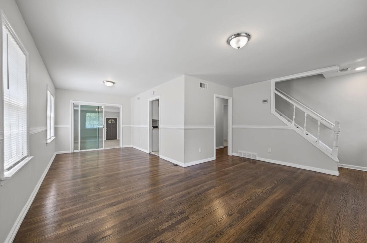 3843 Blue Jay Road Memphis, TN 38116 - Photo 6 of 23 Unfurnished living room with stairway and dark wood finished floors