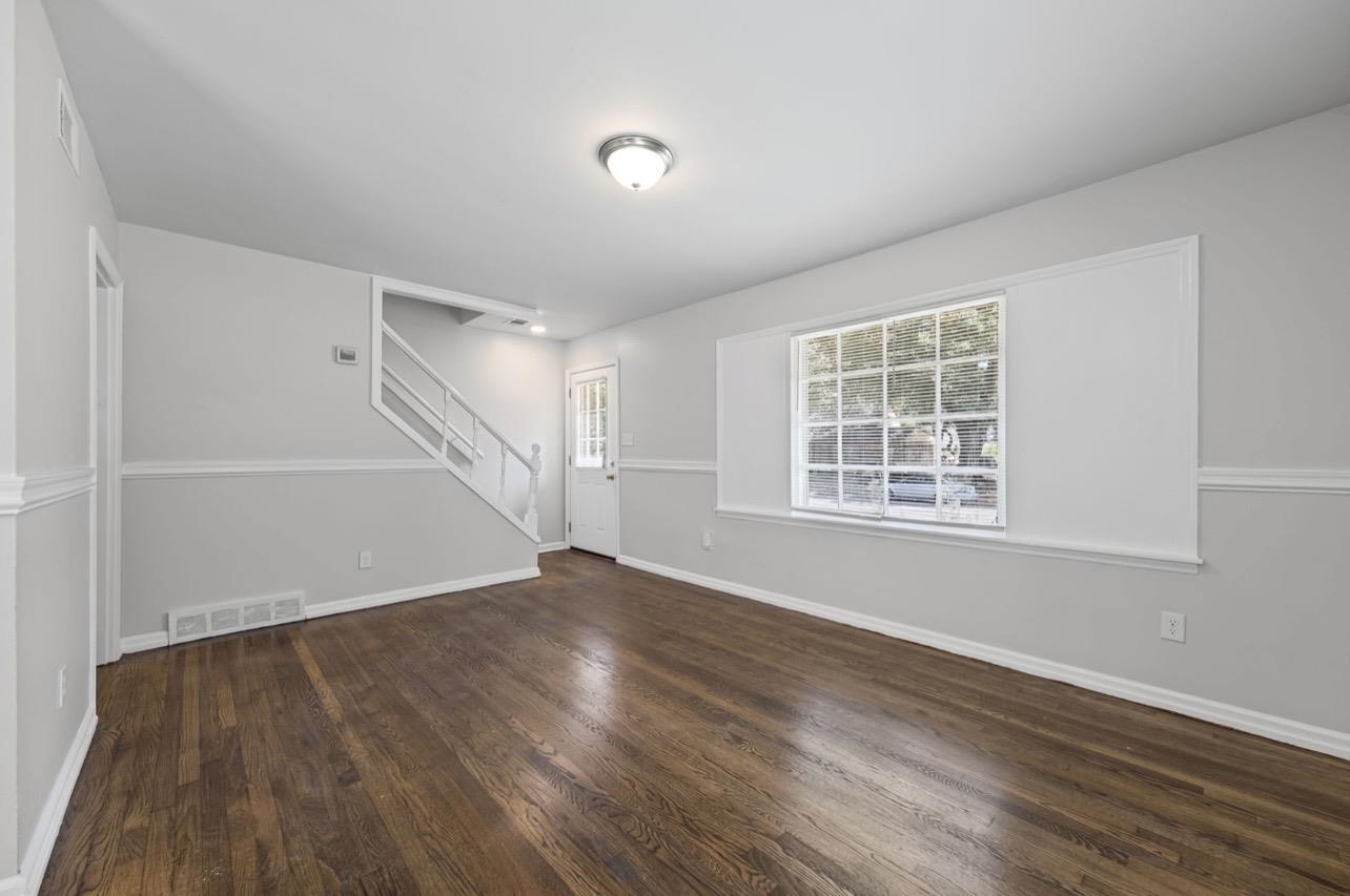 3843 Blue Jay Road Memphis, TN 38116 - Photo 7 of 23 Unfurnished living room with stairway and dark wood finished floors