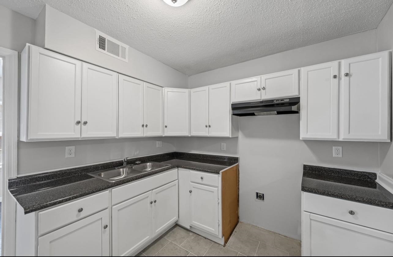 3843 Blue Jay Road Memphis, TN 38116 - Photo 10 of 23 Kitchen with white cabinetry, a textured ceiling, and light tile patterned floors